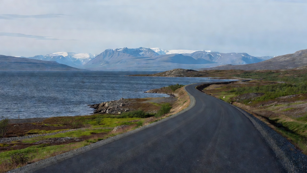 The E10 road following the shore of Lake Torneträsk with mountains near Abisko on the horizon