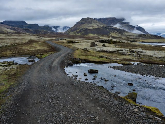 Gravel F-road in the Icelandic highlands leading to a shallow glacial river ford